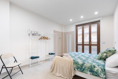 a bedroom with a bed and a chair and a window at La Dama D Piazza Bengasi in Moncalieri