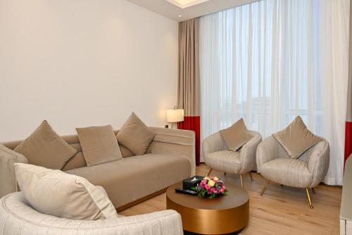 a living room with a couch and two chairs at Comfort Hotel Riyadh Olaya in Riyadh