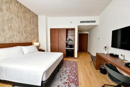 a bedroom with a bed and a desk and a television at Comfort Hotel Riyadh Olaya in Riyadh
