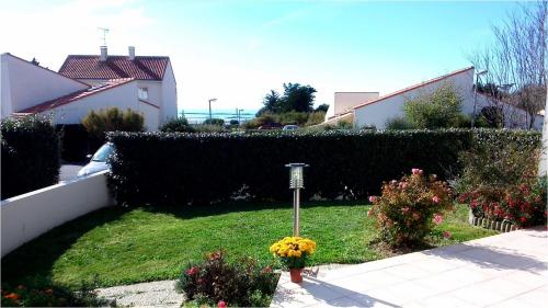 un jardin avec des fleurs et une lampe dans l'herbe dans l'établissement VILLA 3 chbres Vue mer maison avec piscine ds residence proche commodites et plages de sable, à La Bernerie-en-Retz