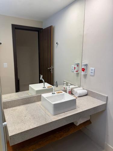 a bathroom with two sinks and a large mirror at Transamerica Dunas de Marapé in Jequia da Praia