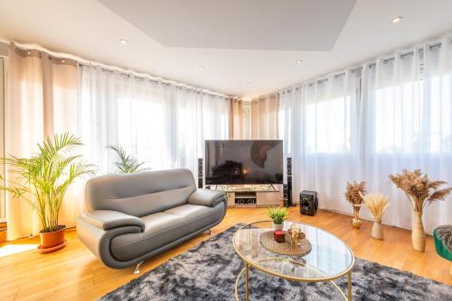 a living room with a couch and a tv at GREAT PLACE Top Penthouse Stuttgart Airport & Messe in Filderstadt