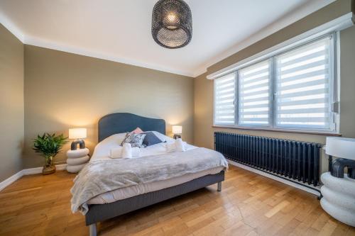 ein Schlafzimmer mit einem Bett und einem großen Fenster in der Unterkunft La Maison Royale - Terrasse et Jardin in Haguenau