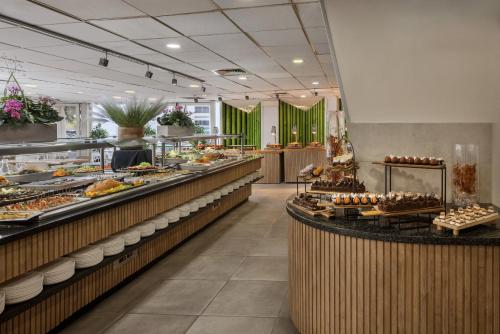 ラマト・ガンにあるKfar Maccabiah Business & Sport Hotelのさまざまな種類の食べ物が並ぶビュッフェライン