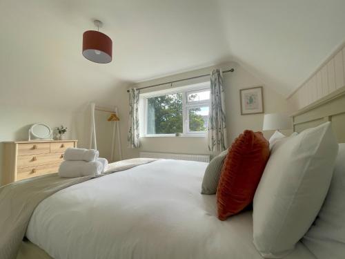 a bedroom with a large white bed with pillows at Fern Cottage in Portinscale
