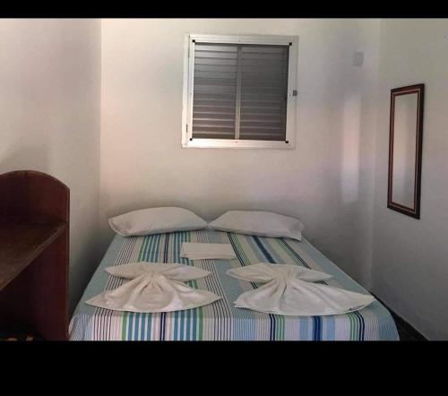 two twin beds in a room with a window at Pousada subauma in Subaúma