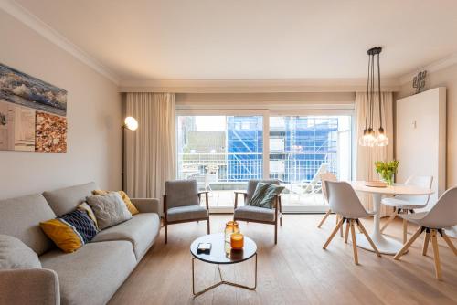 a living room with a couch and chairs and a table at Modern apartment with large terrace close to the sea in Ostend
