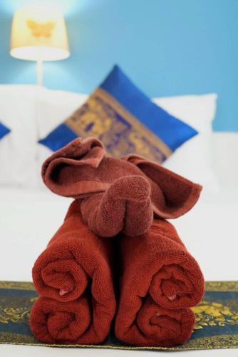 a brown teddy bear sitting on top of a bed at Phannarai House in Lamai