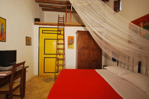 1 dormitorio con cama, escalera y puerta amarilla en Vulcano Consult Cottage, en Lipari