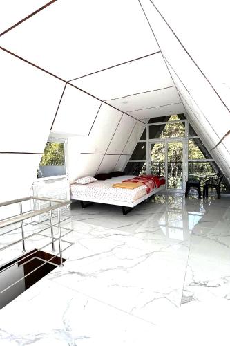 a white room with a bed and a window at Pine Trees Gold in Vagamon