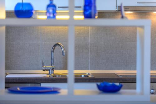 a kitchen counter with a sink and blue dishes at Apartment Island Oasis in Koločep