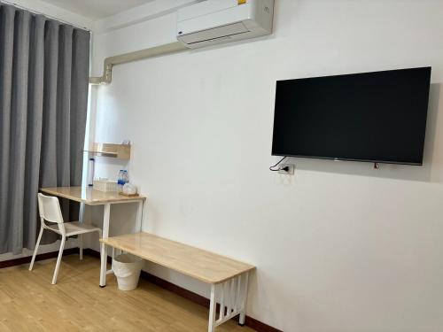 a room with a desk and a tv on a wall at M3 Bangkok Bake & Bed in Bangkok