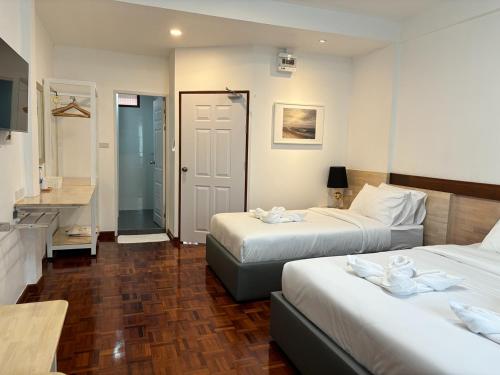 a hotel room with two beds and a bathroom at M3 Bangkok Bake & Bed in Bangkok