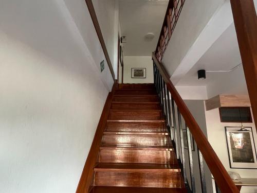 a staircase in a house with wooden floors and white walls at M3 Bangkok Bake & Bed in Bangkok