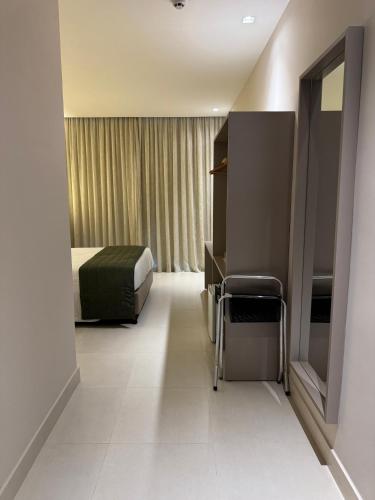 a hotel room with a bed and a chair at Transamerica Dunas de Marapé in Jequia da Praia