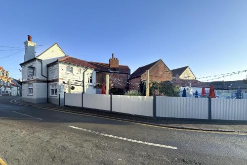 a house with a white fence next to a street at The Lobster in Sheringham