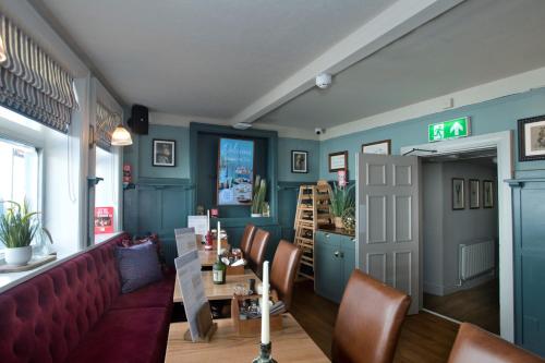 a restaurant with a red couch and a table and chairs at The Lobster in Sheringham