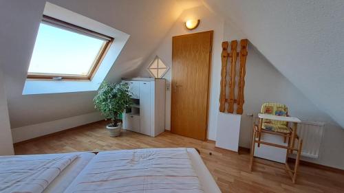 a attic room with a bed and a window at Residenz am Deich NDD 28 in Norden