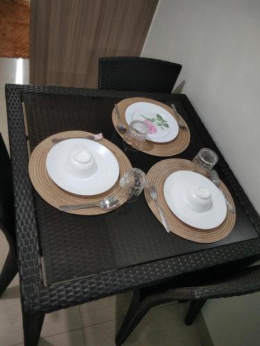 a table with three plates and bowls on it at Shore2 tower2 in Manila