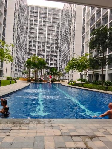 two children playing in a large swimming pool with tall buildings at Shore2 tower2 in Manila
