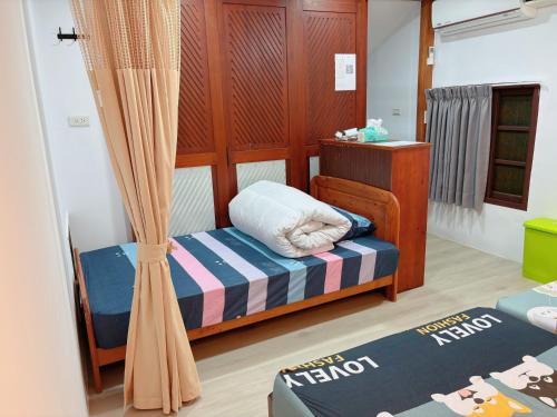 a small room with a bed and a curtain at Chongguang Hotel in Tainan