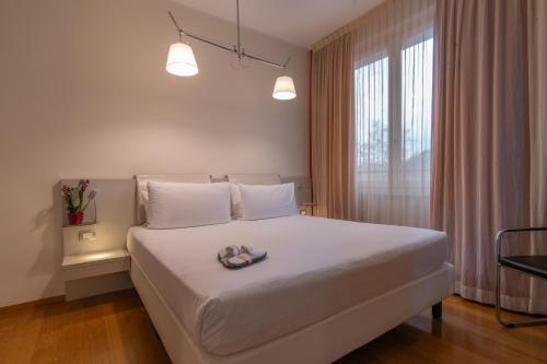 a bedroom with a large white bed and a window at Hotel Mercure Milano Solari in Milan