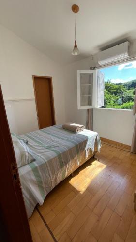 a bedroom with a bed and a large window at Casa para alugar 3 suítes e um Quarto in Campinas
