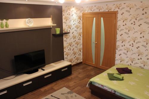 een kleine kamer met een televisie en een deur bij Svetlana's Apartments in Sumy