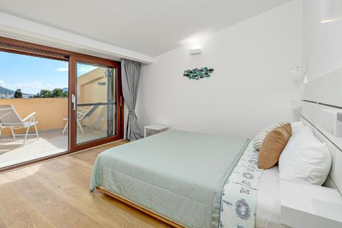 Ginepro Apartment - by And service في Casa Tamponi: غرفة نوم بها سرير وباب زجاجي منزلق