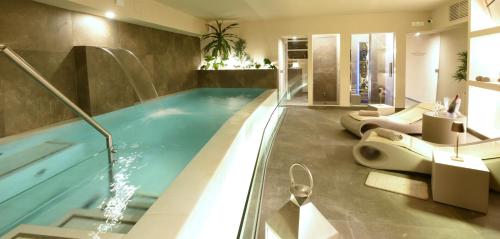a bathroom with a swimming pool with two sinks and toilets at Suite Hotel Santa Chiara in Lecce
