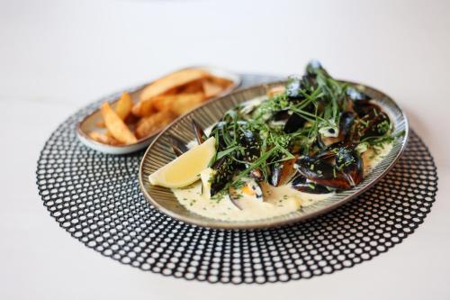 a plate of food on a table with french fries at Suncity Hotel & SPA in Šiauliai
