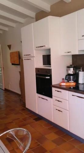 une cuisine avec des armoires blanches et un four à plaques de cuisson dans l'établissement Villa santa karina, à Linguizzetta