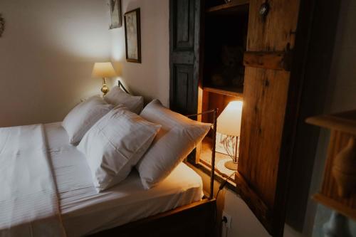 a bedroom with a bed with white sheets and pillows at Ewas Cretan Vintage Houses- Pet Friendly in Kharkhalianá