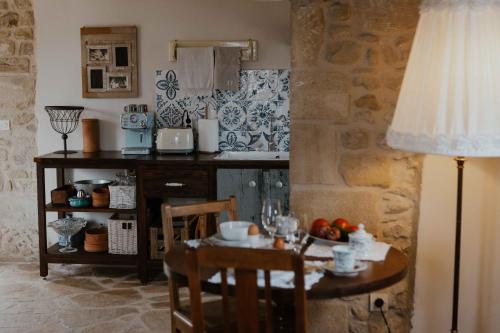 a kitchen with a small table and a table with a lamp at Ewas Cretan Vintage Houses- Pet Friendly in Kharkhalianá