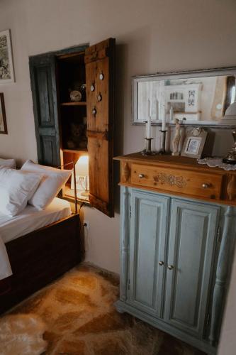 a bedroom with a bed and a blue cabinet with a mirror at Ewas Cretan Vintage Houses- Pet Friendly in Kharkhalianá