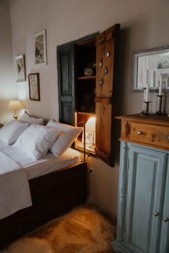 a bedroom with a bed and a dresser with candles on it at Ewas Cretan Vintage Houses- Pet Friendly in Kharkhalianá