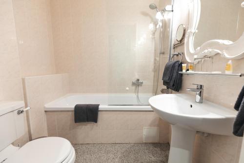 a bathroom with a sink and a toilet and a bath tub at Forums Boutique Hotel in Rīga