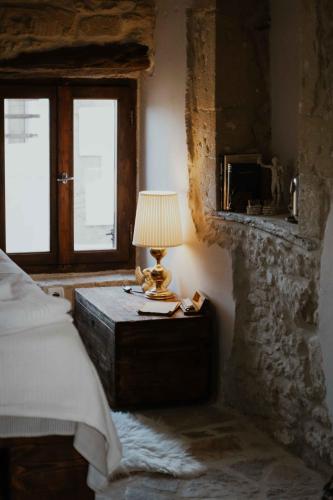 a bedroom with a bed and a lamp on a table at Ewas Cretan Vintage Houses- Pet Friendly in Kharkhalianá
