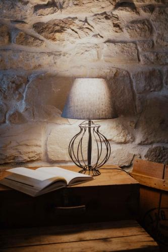 a lamp sitting on a table with an open book at Ewas Cretan Vintage Houses- Pet Friendly in Kharkhalianá