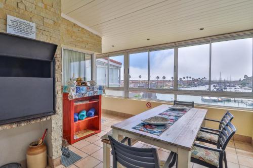 a dining room with a table and a large window at Harbour Lights in Velddrif