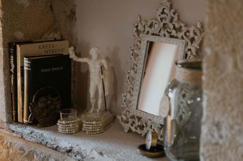 a shelf with a mirror and a statue on it at Ewas Cretan Vintage Houses- Pet Friendly in Kharkhalianá
