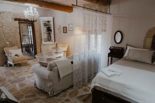 a bedroom with a bed and a chair and a table at Ewas Cretan Vintage Houses- Pet Friendly in Kharkhalianá