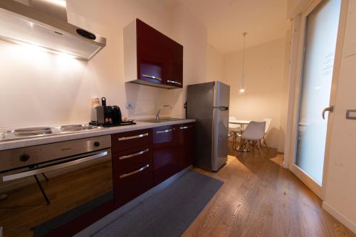 a kitchen with a stainless steel refrigerator and wooden cabinets at Hotel Mercure Milano Solari in Milan
