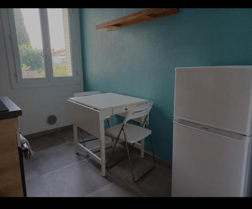 une petite cuisine avec un bureau blanc et un réfrigérateur dans l'établissement Superbe appartement proche des plages - Mourillon - WiFi, à Toulon