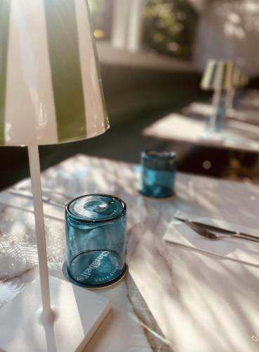 a table with a lamp and two blue candles at Rosedon - Adults Only from Jan 2025 in Hamilton