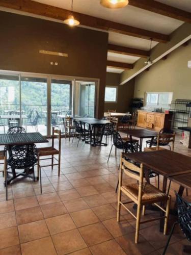une salle à manger avec tables, chaises et fenêtres dans l'établissement Auberge chez François, à Ortale