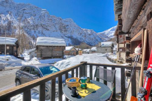 a table on a balcony with a view of a mountain at Rustico Al Museo Bosco Gurin - Happy Rentals in Bosco Gurin