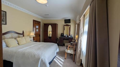 a bedroom with a large bed and a desk at Foley's Townhouse Killarney in Killarney