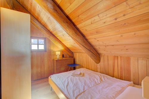 a bedroom with a bed in a wooden attic at Rustico Al Museo Bosco Gurin - Happy Rentals in Bosco Gurin