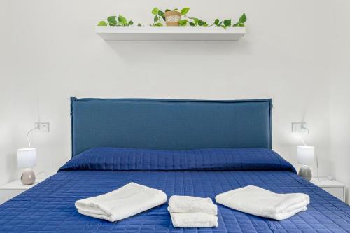 a blue bed with two white towels on it at I giardini di Cala D'ambra in San Teodoro